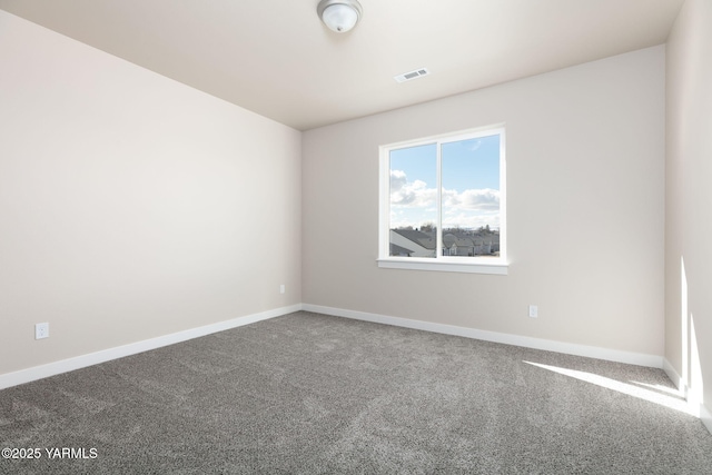 spare room featuring carpet and baseboards