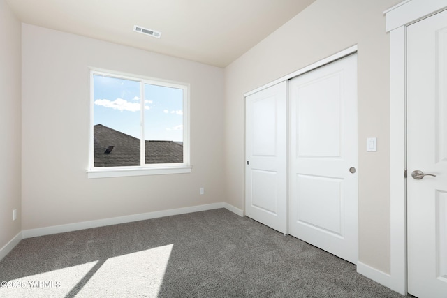 unfurnished bedroom featuring a closet, carpet flooring, visible vents, and baseboards