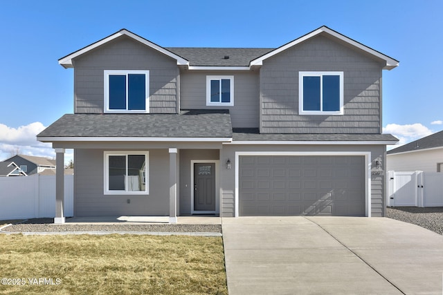 traditional home featuring a shingled roof, an attached garage, a gate, fence, and driveway