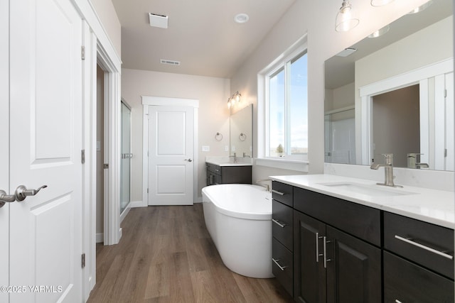 full bathroom featuring a shower stall, visible vents, a sink, and wood finished floors