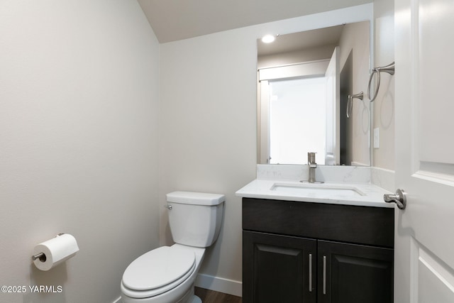 bathroom with vanity, toilet, and baseboards