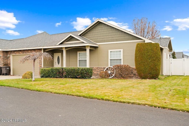 view of front facade featuring driveway, stone siding, an attached garage, fence, and a front yard