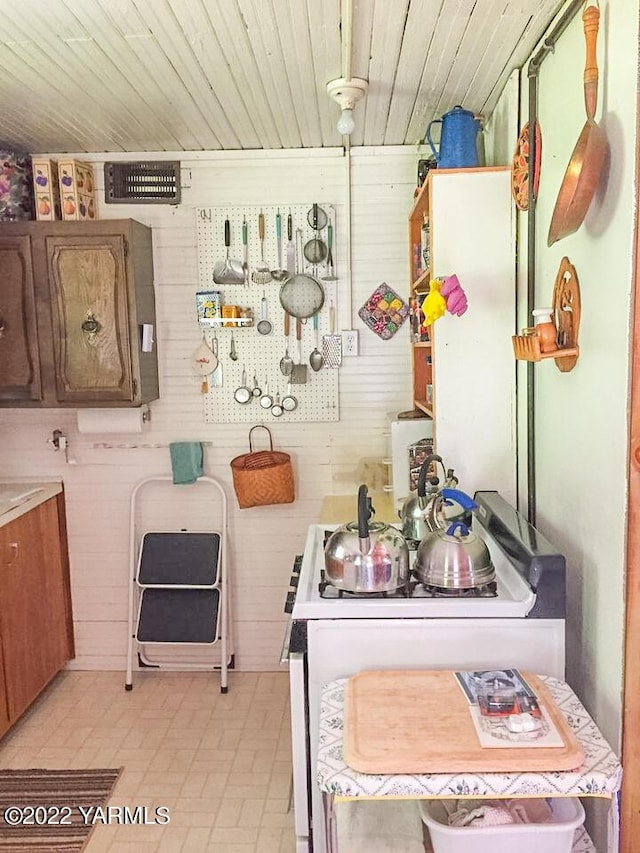 30711 Hwy 410, Naches, WA 98937 - kitchen featuring white range oven, brown cabinetry, light countertops, wooden walls, and wooden ceiling