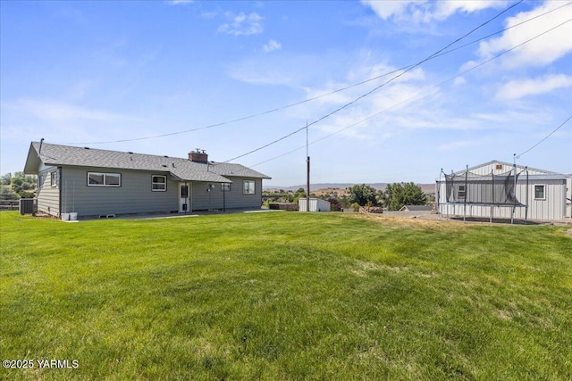 101 Hickory Ln, Selah, WA 98942 - view of green lawn with a trampoline and a storage unit