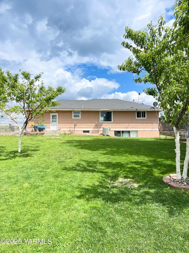 1341 Cemetery Rd, Sunnyside, WA 98944 - rear view of house featuring a trampoline, central AC, and a yard