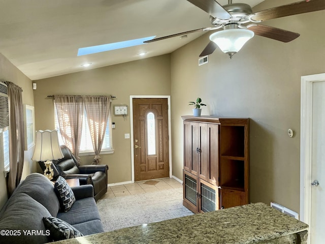 106 S G St, Toppenish, WA 98948 - living area featuring light tile patterned floors, a ceiling fan, visible vents, baseboards, and vaulted ceiling with skylight