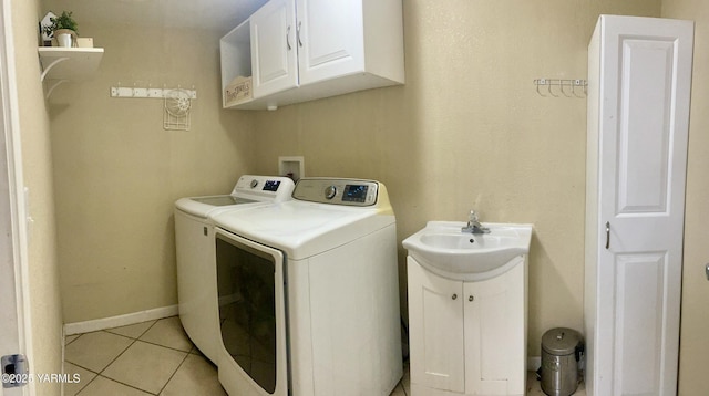 106 S G St, Toppenish, WA 98948 - washroom featuring washer and clothes dryer, a sink, cabinet space, light tile patterned floors, and baseboards