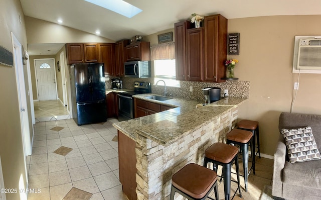 106 S G St, Toppenish, WA 98948 - kitchen featuring lofted ceiling with skylight, a sink, tasteful backsplash, stainless steel appliances, and a peninsula