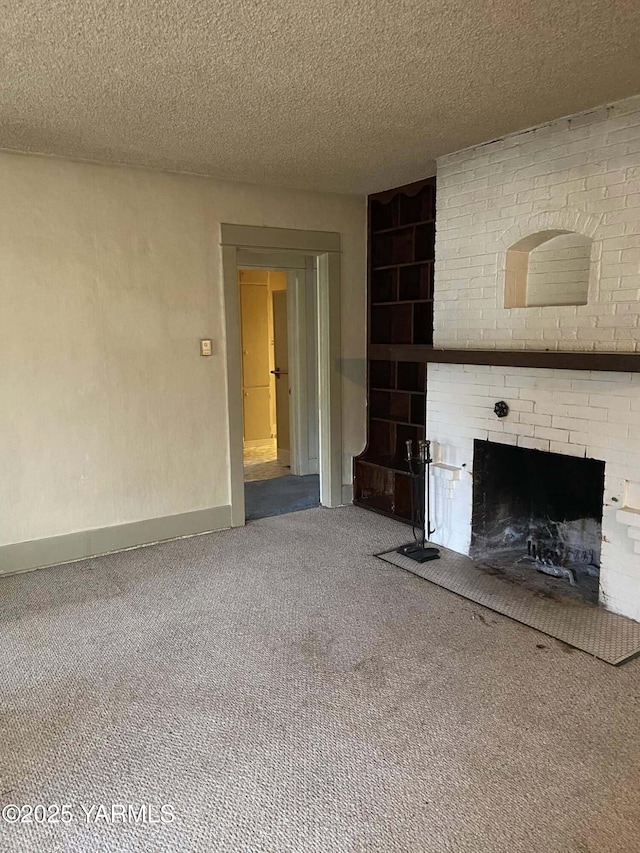 unfurnished living room featuring a textured ceiling, a fireplace, baseboards, and carpet flooring