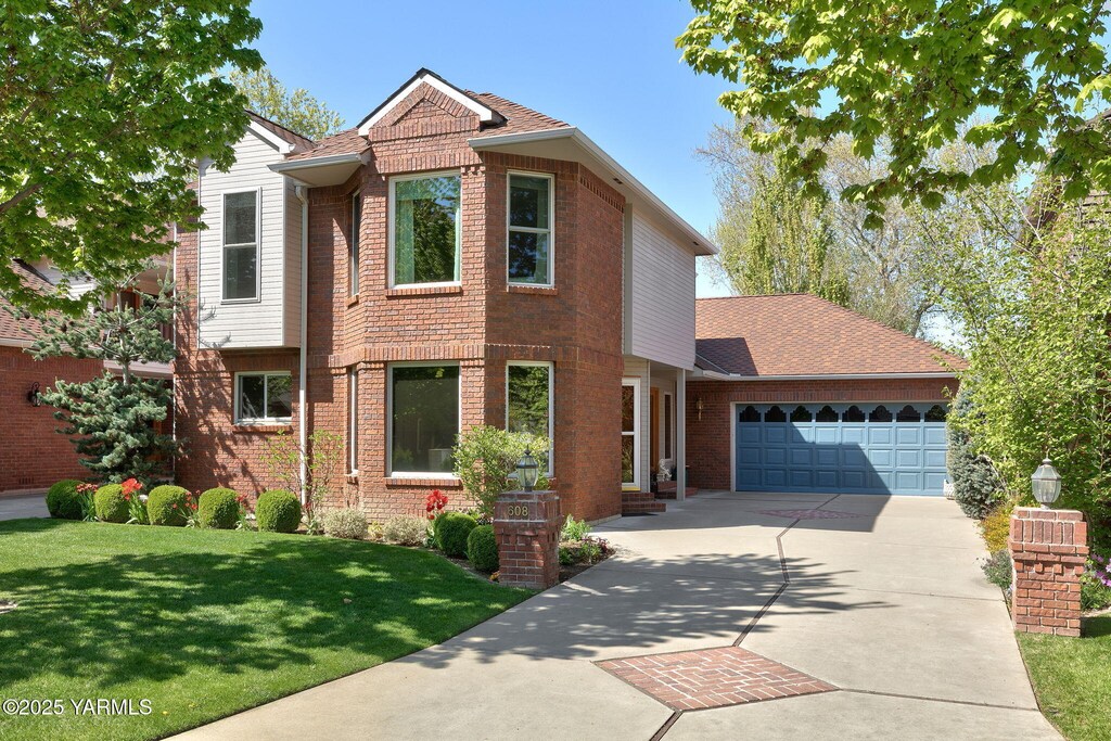 608 Bellevue Pl, Yakima, WA 98908 - view of front of home with a front yard, a garage, brick siding, concrete driveway, and a shingled roof