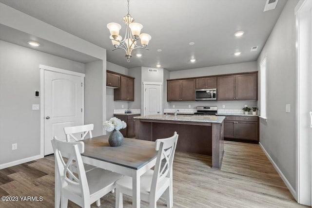 dining room with light wood-style floors, baseboards, a notable chandelier, and recessed lighting