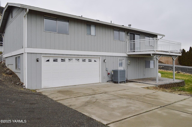 view of front of house featuring central air condition unit, a balcony, and an attached garage