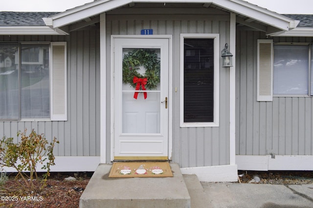 property entrance featuring a shingled roof and board and batten siding