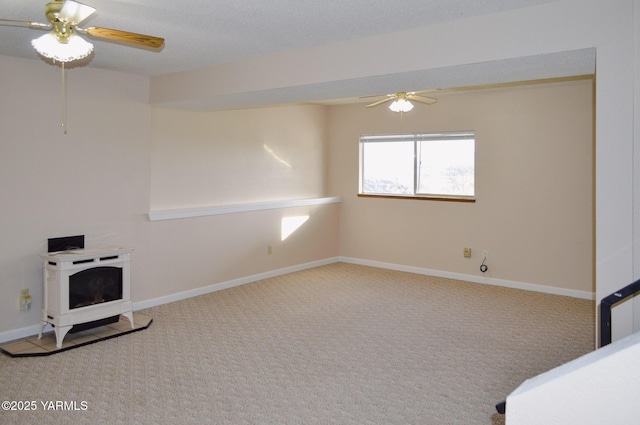 interior space with carpet, baseboards, a wood stove, and ceiling fan