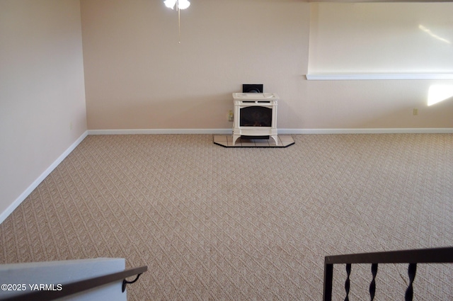 room details featuring carpet flooring, baseboards, and a wood stove