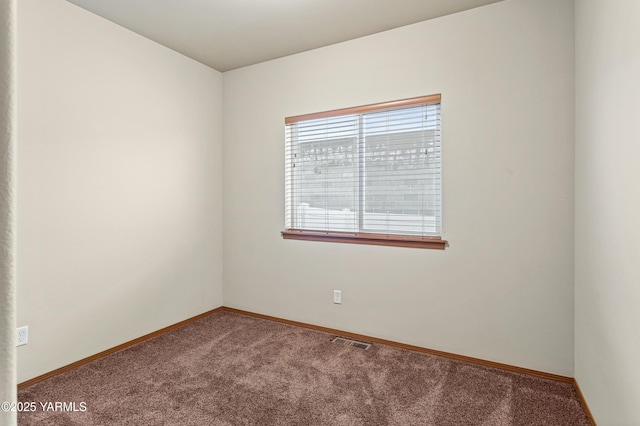 carpeted spare room with visible vents and baseboards