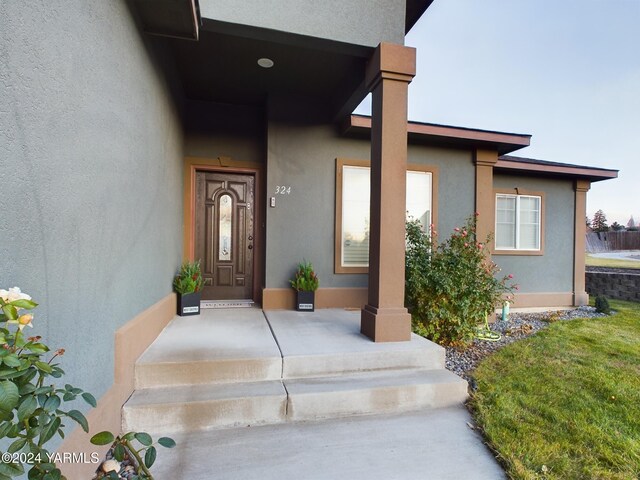 doorway to property featuring stucco siding