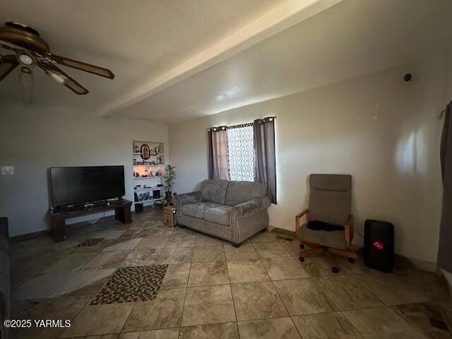 living area with a ceiling fan and beamed ceiling