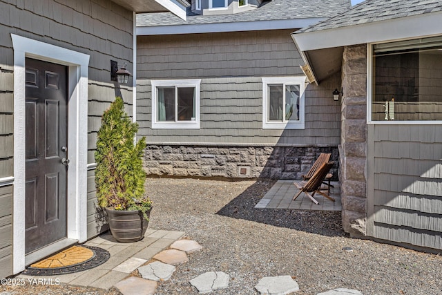 12826 Douglas Rd, Yakima, WA 98908 - view of exterior entry featuring stone siding, a shingled roof, and a patio