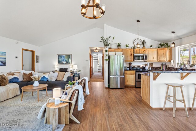 12826 Douglas Rd, Yakima, WA 98908 - kitchen featuring appliances with stainless steel finishes, a breakfast bar area, dark wood finished floors, a chandelier, and open floor plan