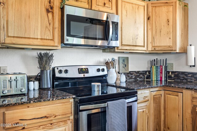 12826 Douglas Rd, Yakima, WA 98908 - kitchen featuring appliances with stainless steel finishes, dark stone countertops, and backsplash