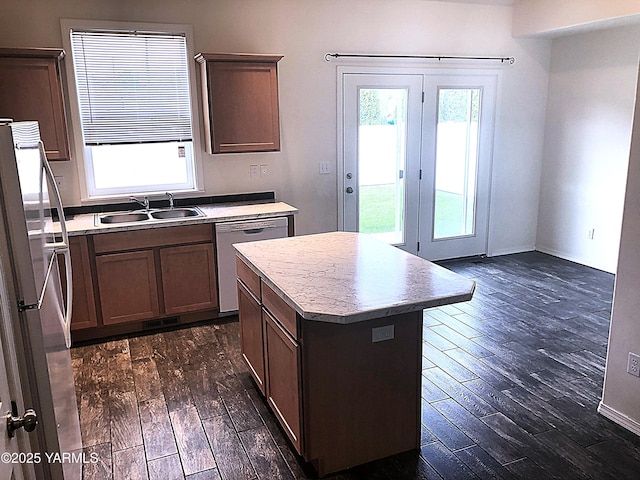 kitchen featuring freestanding refrigerator, dark wood-style flooring, a sink, and dishwashing machine