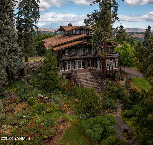 back of property featuring a chimney, stairway, and a mountain view