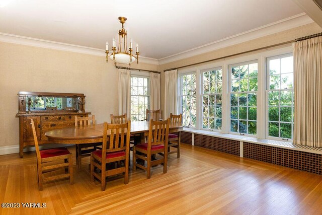 dining room with a chandelier, parquet floors, ornamental molding, and baseboards