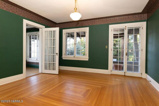 interior space featuring wallpapered walls, baseboards, ornamental molding, and french doors