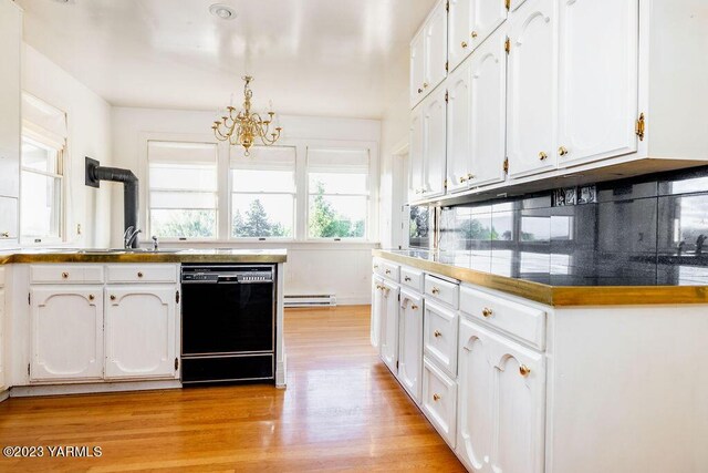 kitchen with black dishwasher, decorative light fixtures, dark countertops, white cabinets, and a sink