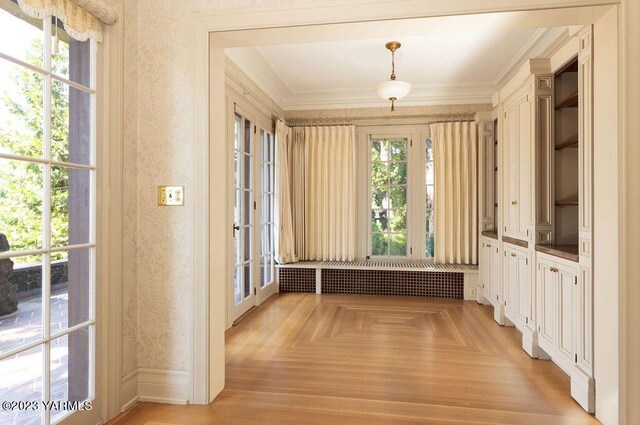 interior space featuring ornamental molding, radiator heating unit, plenty of natural light, and wallpapered walls