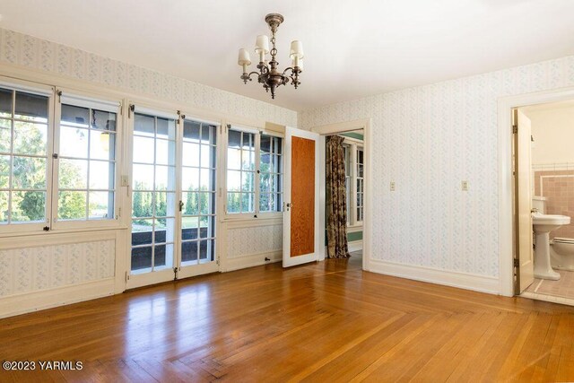 spare room featuring baseboards, plenty of natural light, and wallpapered walls