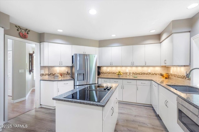 621 Friedline Rd, Yakima, WA 98908 - kitchen with stainless steel appliances, light wood-style flooring, tasteful backsplash, a kitchen island, and recessed lighting