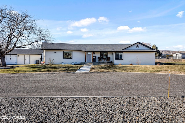 single story home featuring a front yard, fence, and stucco siding