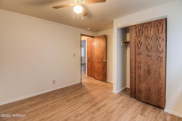 unfurnished bedroom featuring light wood finished floors, baseboards, and a closet