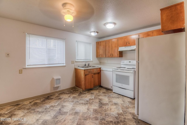 kitchen featuring under cabinet range hood, white appliances, a sink, light countertops, and brown cabinets