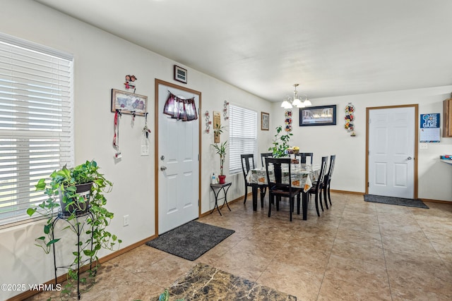 dining room featuring an inviting chandelier and baseboards