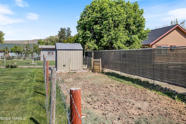 view of yard featuring a fenced backyard, a storage unit, and an outbuilding