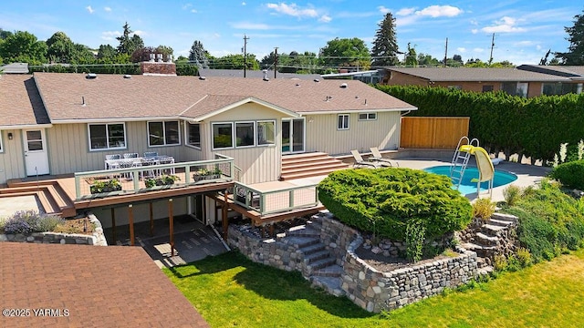 5310 W Lincoln Ave, Yakima, WA 98908 - back of property with a wooden deck, an outdoor pool, a chimney, and a patio area