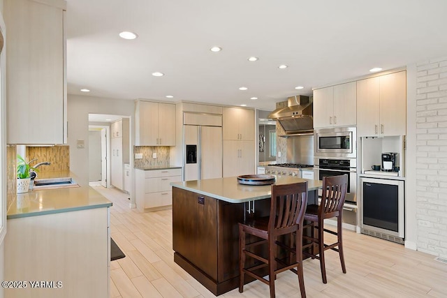 5310 W Lincoln Ave, Yakima, WA 98908 - kitchen with built in appliances, exhaust hood, wine cooler, a kitchen breakfast bar, and decorative backsplash