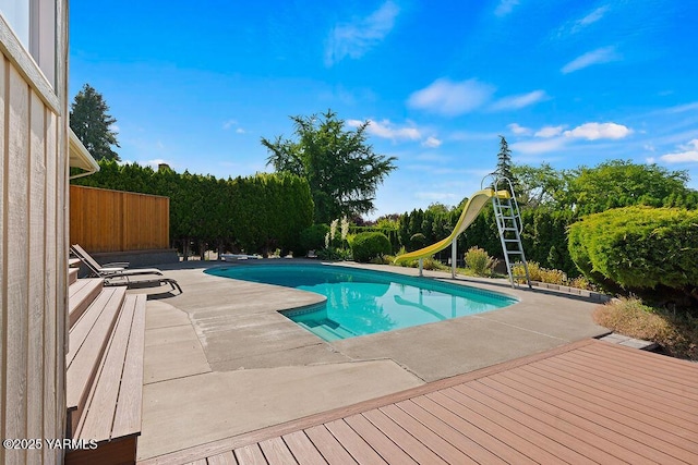 5310 W Lincoln Ave, Yakima, WA 98908 - outdoor pool featuring a patio, a water slide, and view of wooded area