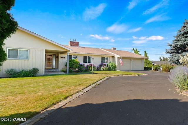 5310 W Lincoln Ave, Yakima, WA 98908 - ranch-style home with a chimney, an attached garage, a front lawn, asphalt driveway, and board and batten siding