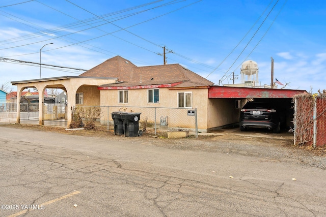 exterior space with roof with shingles, fence, and stucco siding