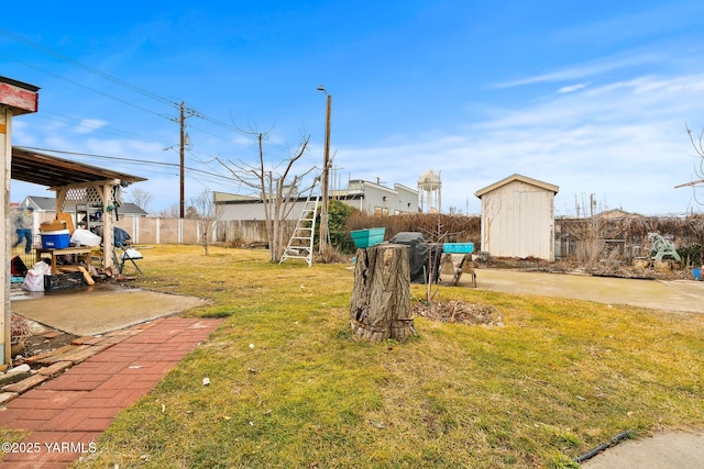 view of yard featuring an outbuilding, fence, and a storage unit