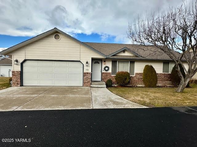 ranch-style home with a garage, driveway, and brick siding