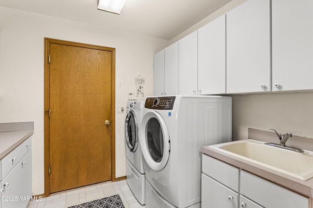 washroom featuring cabinet space, a sink, and washer and clothes dryer