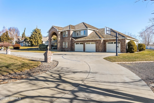 view of front of property featuring a garage, a front lawn, concrete driveway, and brick siding