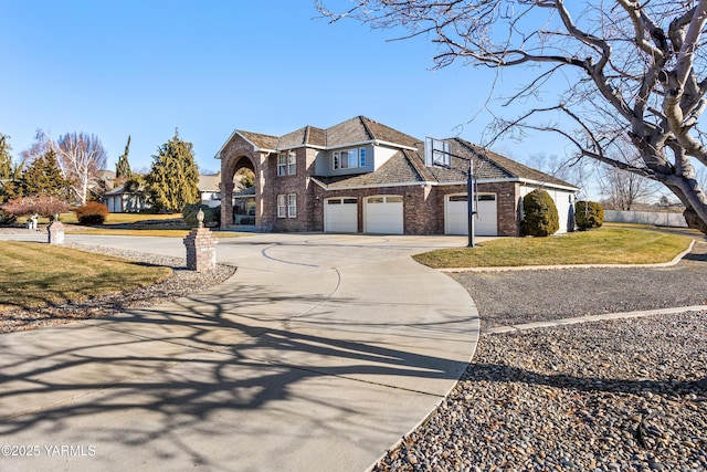 view of front facade with a garage, a front yard, concrete driveway, and brick siding