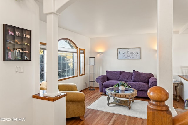 living room featuring wood finished floors and decorative columns