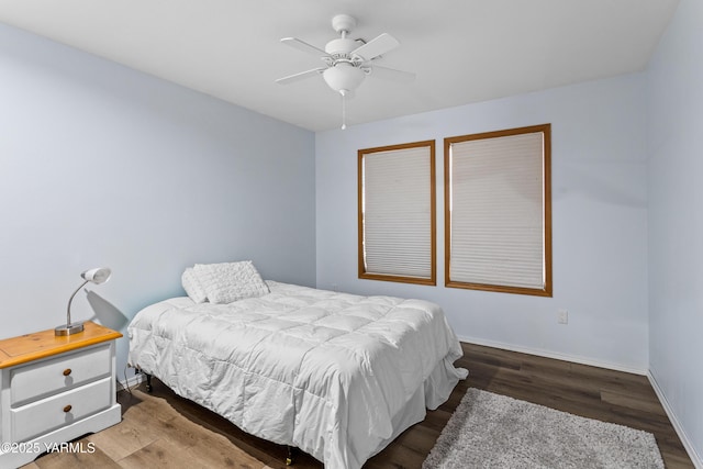 bedroom featuring ceiling fan, wood finished floors, and baseboards